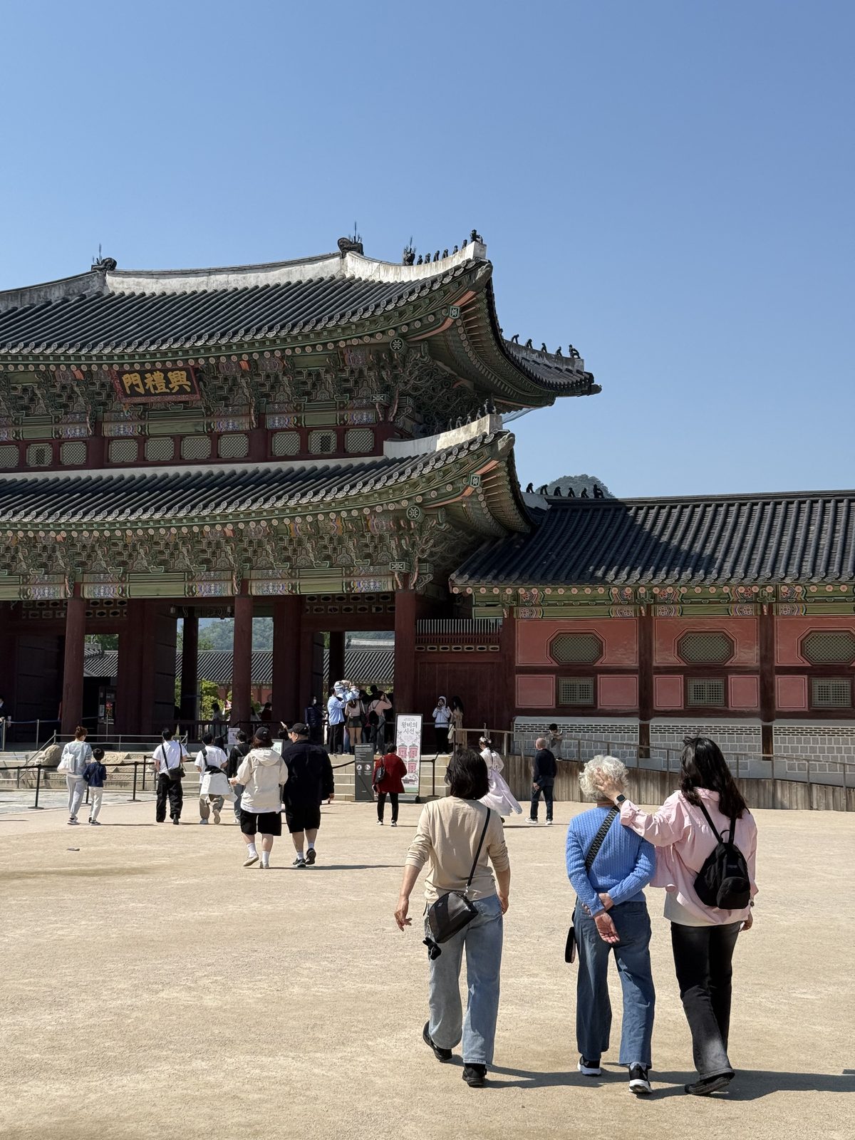 Heungnyemun, the second gate of Gyeongbokgung Palace, with visitors crossing the wide courtyard toward it