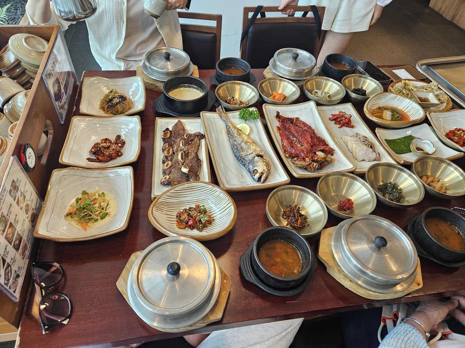 A Jeju-style hanjeongsik with grilled galchi cutlassfish and brass bowls of side dishes