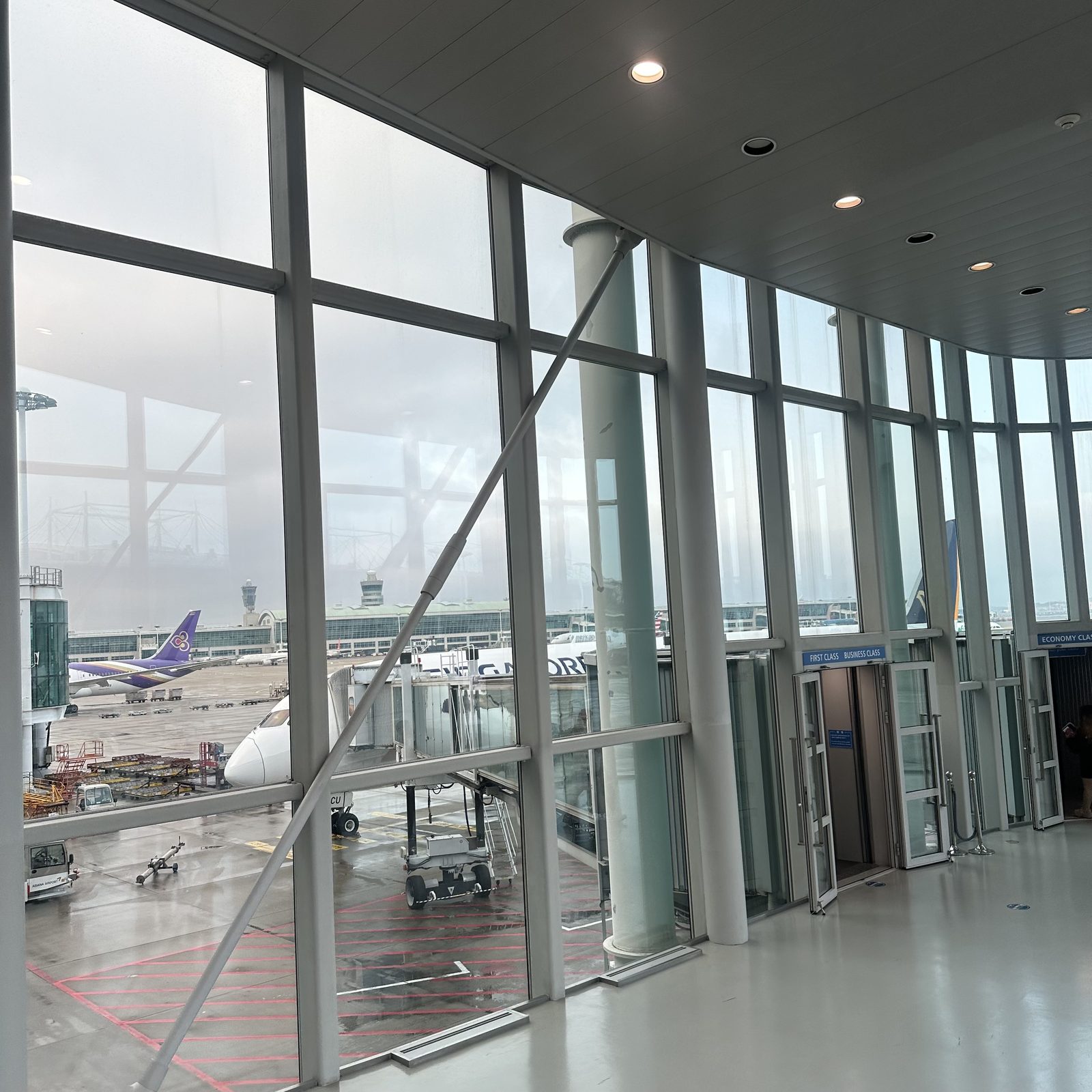 Floor-to-ceiling windows at an Incheon Airport Terminal 1 gate, with a plane parked at the gate outside