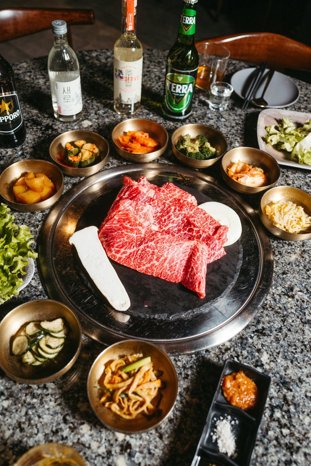 Marbled Korean BBQ beef grilling over charcoal