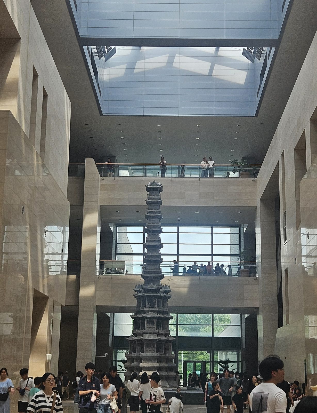 The ten-storey stone pagoda from Gyeongcheonsa rising through the central hall of the National Museum of Korea under a skylight