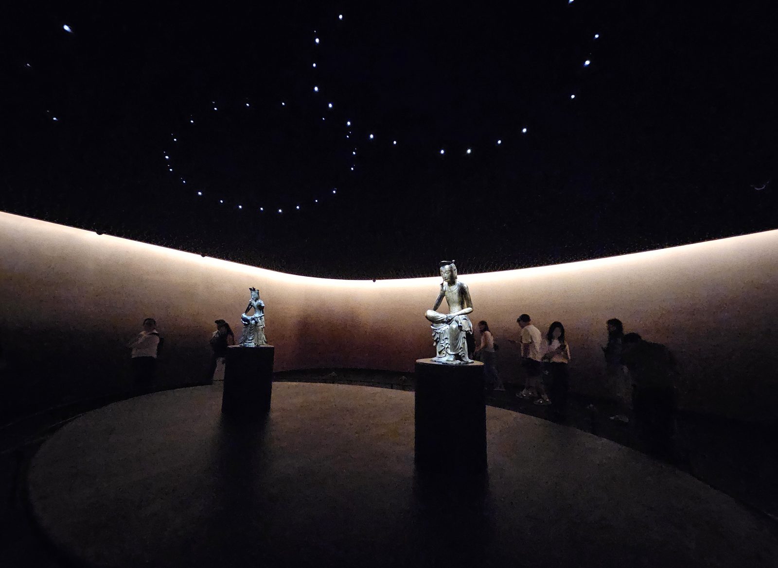 The two gilt-bronze Pensive Bodhisattvas on plinths in the dimly lit Room of Quiet Contemplation at the National Museum of Korea