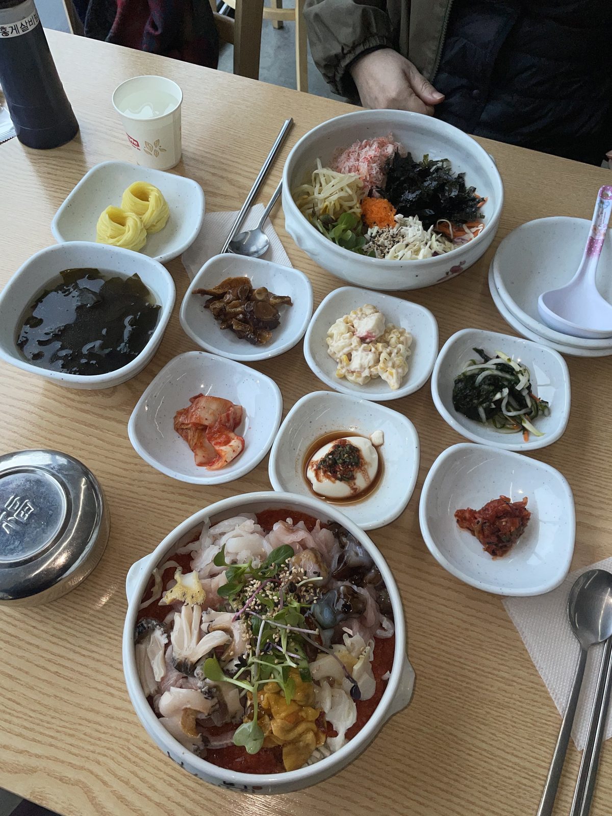 A red crab bibimbap set in Sokcho served with a spread of small side dishes